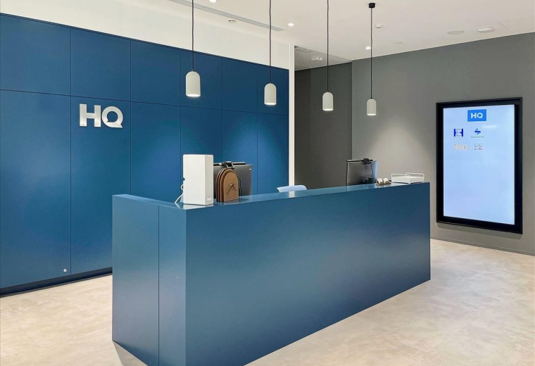 A modern blue reception desk at K11 Atelier, 728 King’s Road with sleek pendant lighting.