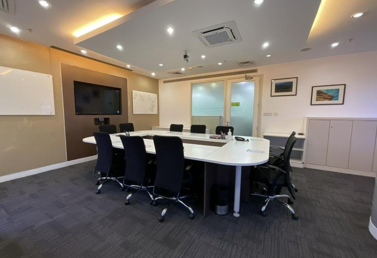 Professional conference room with a large white table and integrated AV equipment.