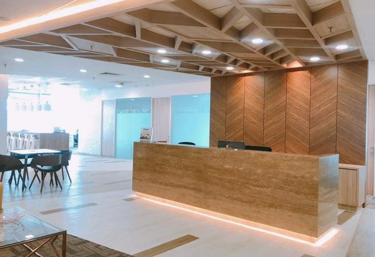 Reception area at Level 31 Axiata tower with a sleek wooden desk and geometric ceiling design.