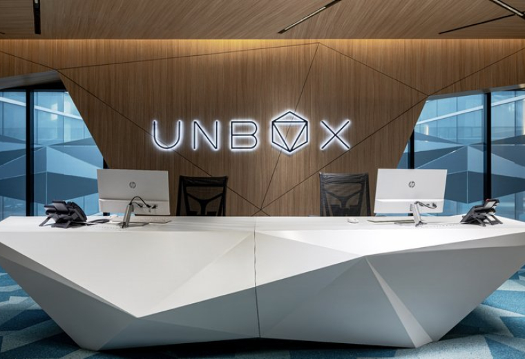 Futuristic white geometric reception desk at 4th Floor, with wood-paneled feature wall and logo.