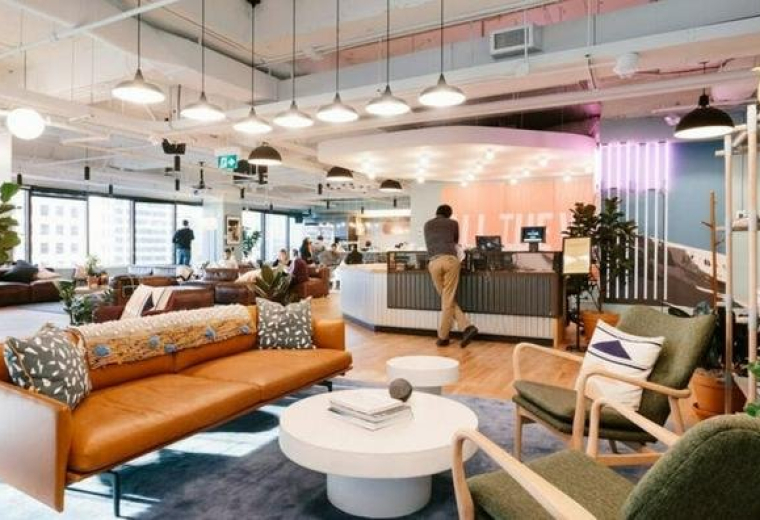 Spacious communal lounge with a leather sofa, mid-century chairs, and warm lighting at 1-24-3, Minami Aoyama.