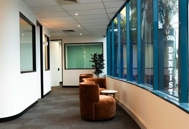 Spacious reception area at 1044A, Dandenong Road, Carnegie with brown velvet armchairs and large windows.