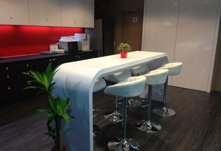 Modern pantry area with a white curved bar counter and high-backed white stools.