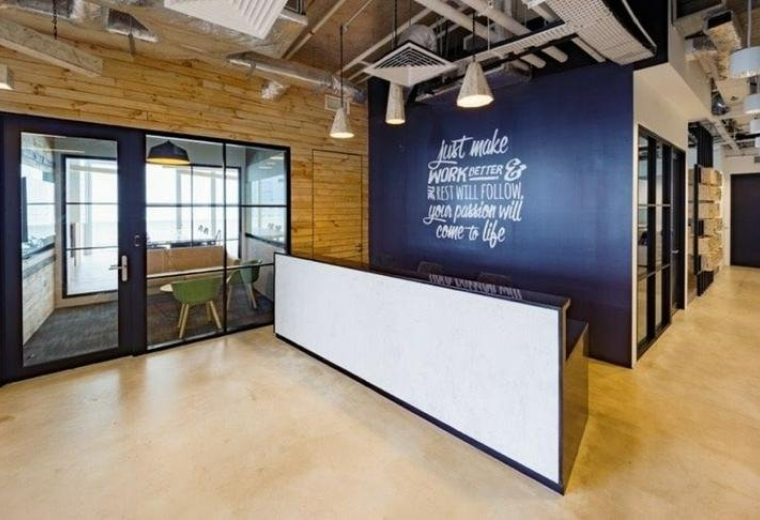 Modern reception area with a white front desk and blue feature wall at 120 Robinson Road, Tanjong Pagar.
