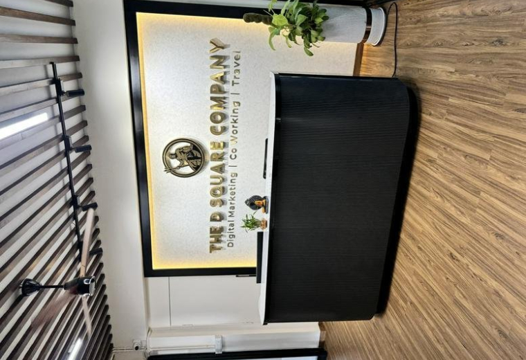 Branded reception area at 139, 5th Main Rd, 6th sector, HSR Layout, featuring a black desk and wooden floors.