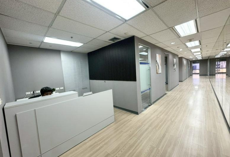 Modern reception area at 159, Sukhumvit 21 Road with a white front desk and grey feature walls.