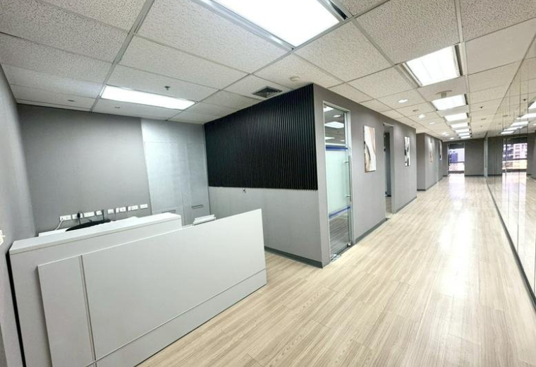 Spacious reception area at 159 Sukhumvit 21 Rd with a modern white desk and wood-style flooring.