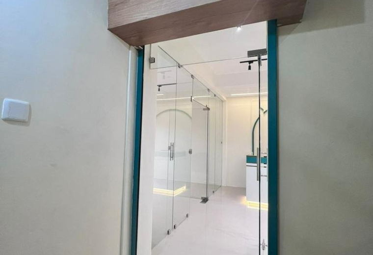 Modern glass entrance to the 163B, Venkatachalam Chetty Street office with wood-paneled header.