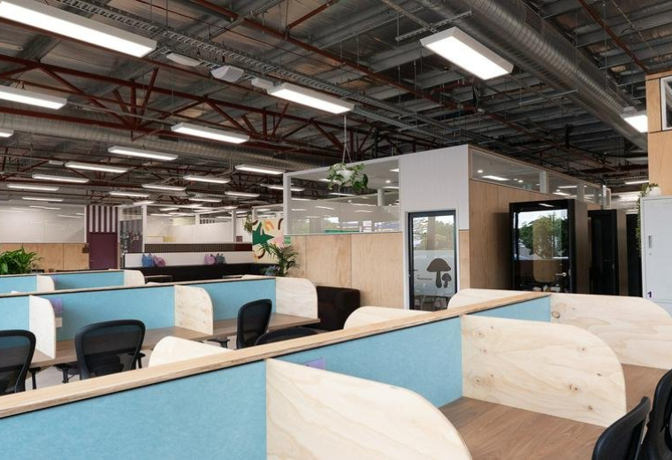 Spacious open-plan workspace at 182 Monash Drive, Dandenong South featuring modern blue and wood-panelled cubicles.