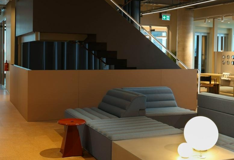 Modern lounge area at 189, Toorak Road with tiered blue seating and a decorative staircase.