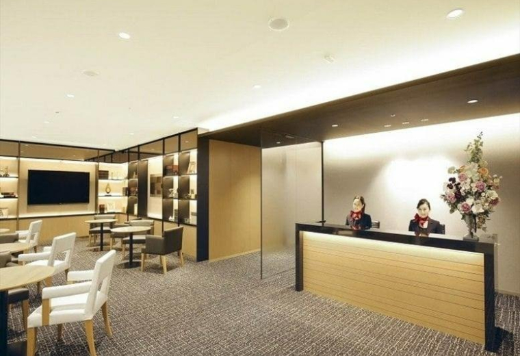 Reception and waiting area at Urbannet Nihonbashi 2-chome with staff behind a modern wooden desk.