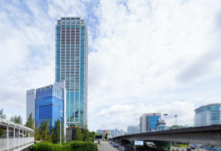 Wide exterior view of the modern glass-facade skyscraper and surrounding cityscape