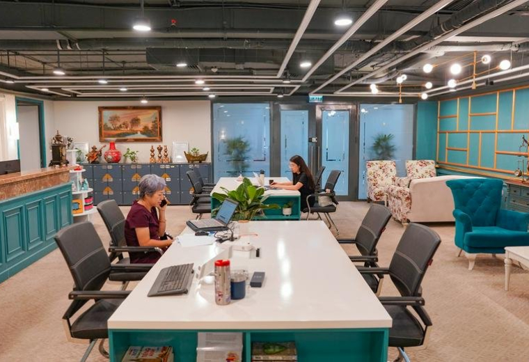 Spacious coworking area with white desks, teal cabinetry, and colorful armchairs at 25, Phố Lý Thường Kiệt, Cửa Nam.