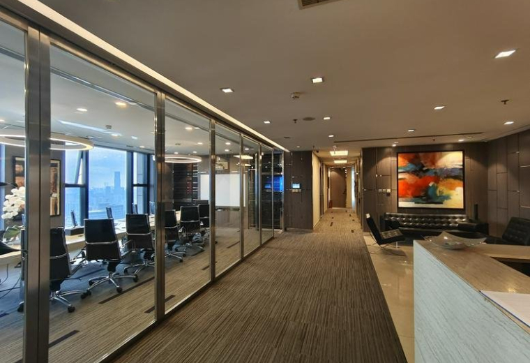 Modern reception lobby with glass partitions and a view into a professional boardroom.