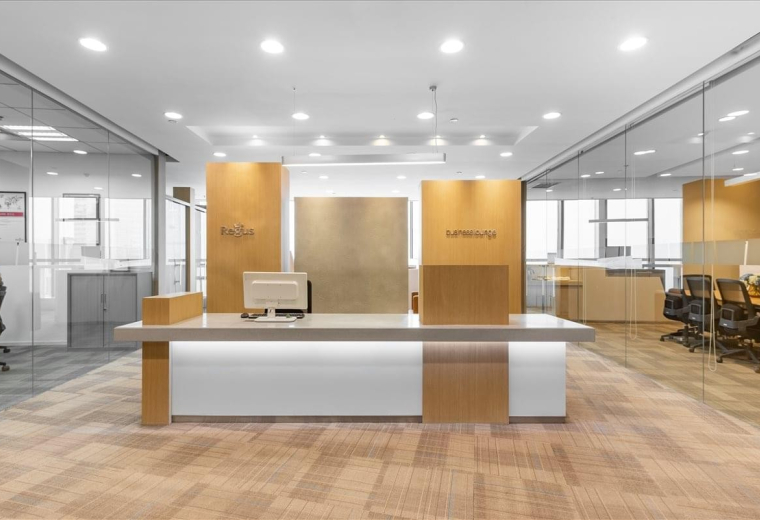 Bright, modern reception area with a minimalist white and wood front desk under recessed lighting.