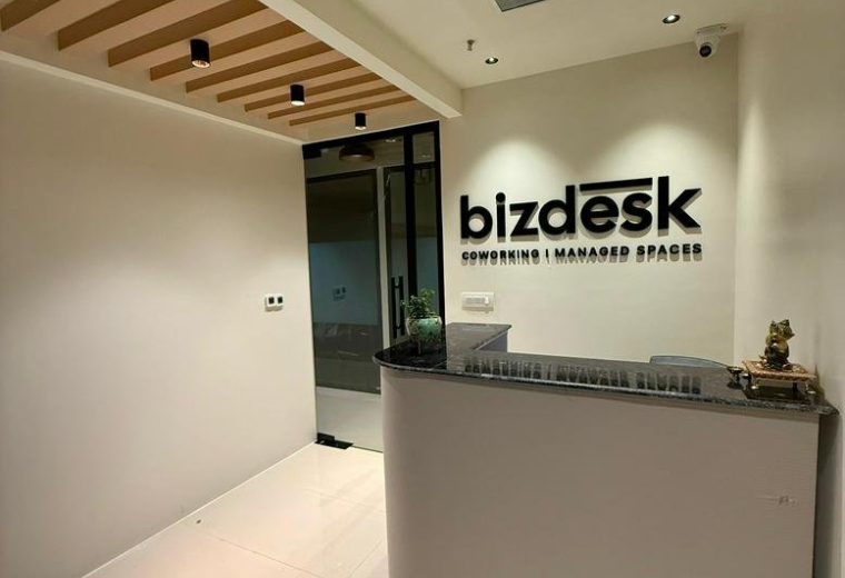 Modern reception area at Iridium, Shalimar Corporate Park with a minimalist front desk and wood-slat ceiling.