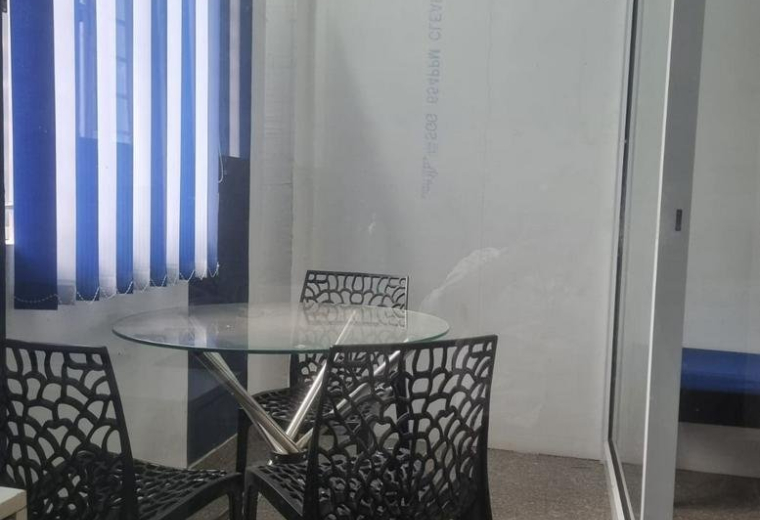 Meeting area at 43, KRG Nagar Main Street with a glass-topped table and black patterned chairs.