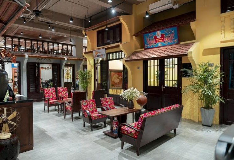 Spacious communal lounge at 44, Tràng Tiền, Hoàn Kiếm with vibrant red seating and traditional architectural details.
