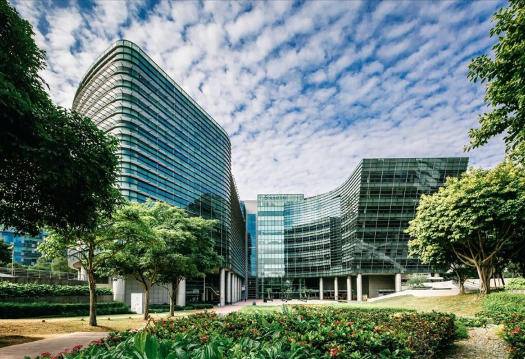 Modern glass-fronted exterior of The Signature, Level 4, Changi Business Park, Singapore under a blue sky.