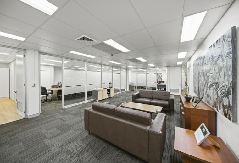 Spacious communal lounge at Sturt Business Centre with leather sofas and large abstract wall art.