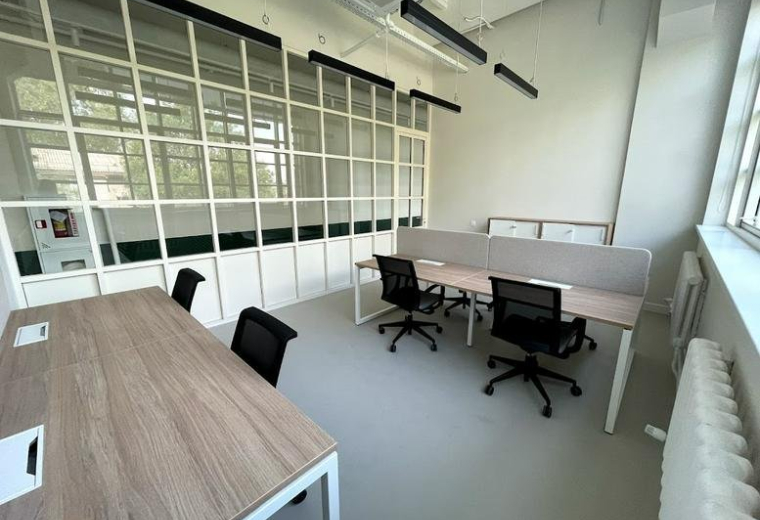 Spacious open-plan workspace at 54, Manshuk Mametova Street with a gridded glass partition.
