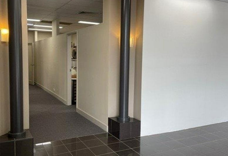 Spacious lobby at 671 - 677 Hunter Street, Newcastle, Australia featuring dark tile floors and architectural columns.