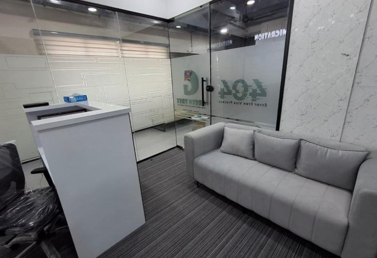 Modern reception area at 74A, Salai Rd featuring a grey sofa and a sleek white desk.