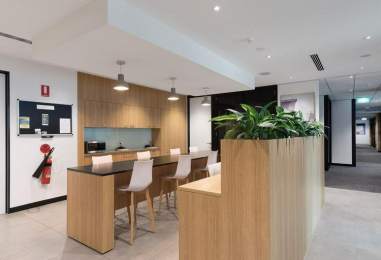 Modern office breakout area at Lobby 1, Level 2, 76 Skyring Terrace with wooden accents and indoor plants.