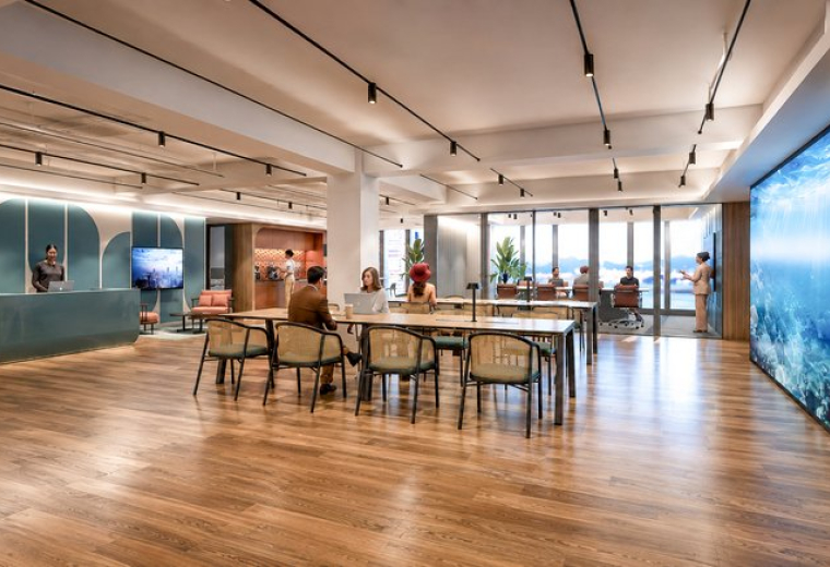 Spacious reception and lounge at 88 Connaught Road Central with wood floors and digital art wall.
