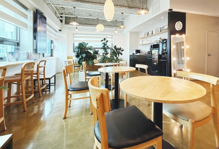 Wide-angle view of Aimhigh Tower featuring a stylish communal area with warm wood finishes.