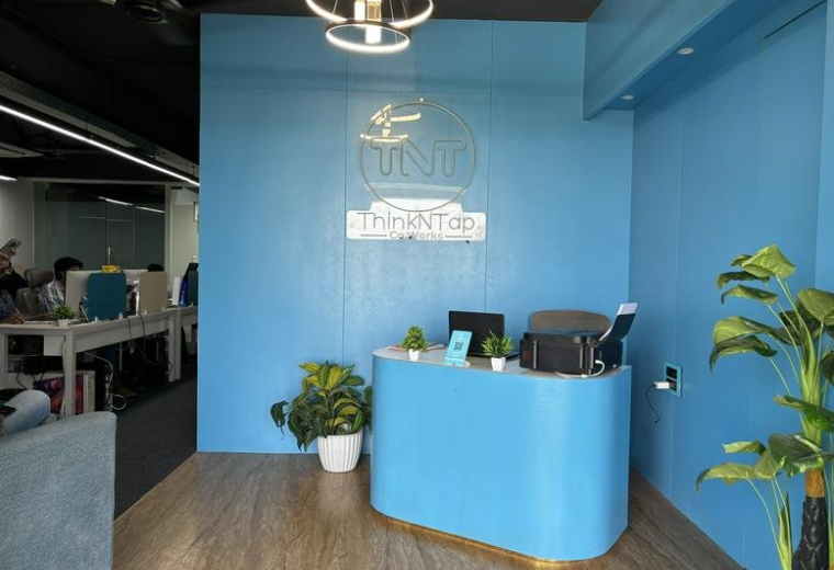 Bright blue reception area at 919, 9th floor, shekhar central with a curved desk and wood-style flooring.
