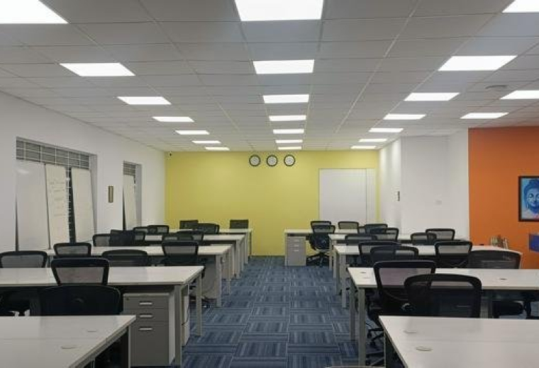 Spacious open-plan workspace at Aishwarya Crystal Layout Road, Singasandra, Bengaluru, India with orange and yellow walls.
