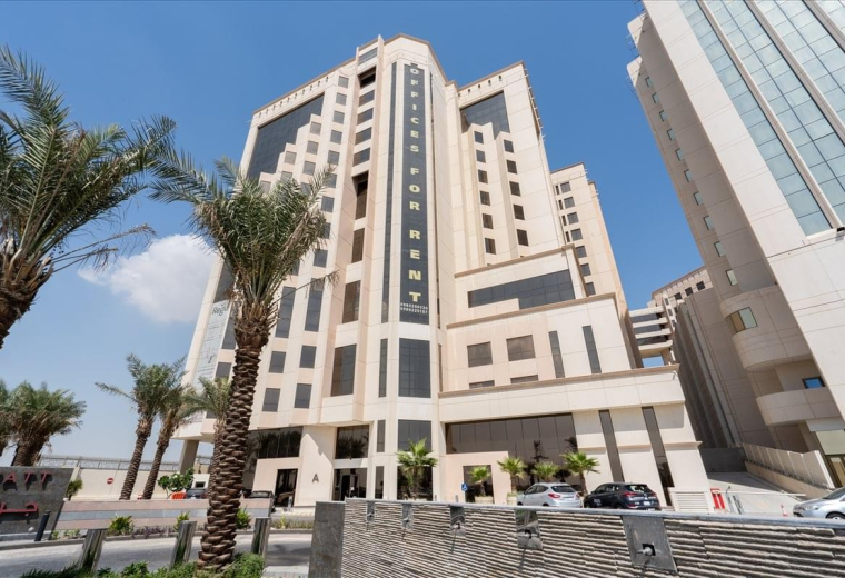 Exterior view of Al Rashed Tower (A) with palm trees outside.