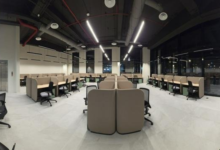 Spacious open-plan workspace at almathar, prince Sultan rd with rows of modern cubicles and bright linear lighting.