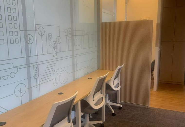 Long wooden desk with ergonomic white chairs at Bremen Chowk, Aundh, Pune, India.