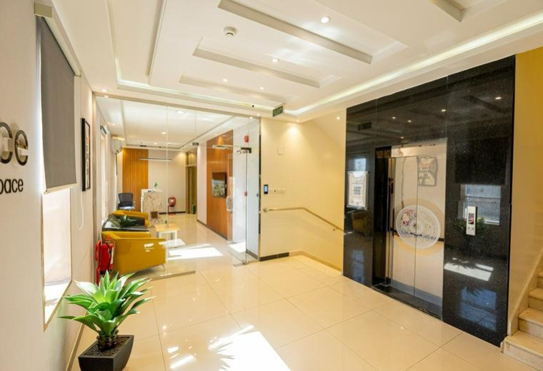 Spacious reception area of Building No. 6143 with polished floors and elegant black elevator doors.
