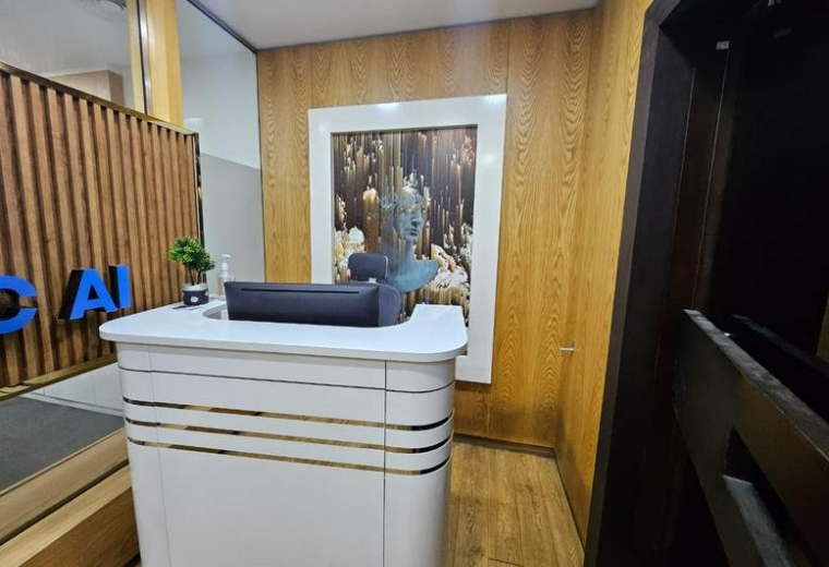 Sleek white reception desk at Concord Tower me with wooden wall panelling and a large framed artwork.