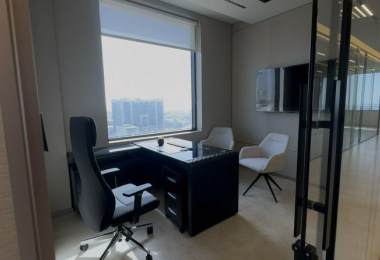 Modern workspace at Dar Rayhan by Rotana featuring a sleek black desk and panoramic city views.