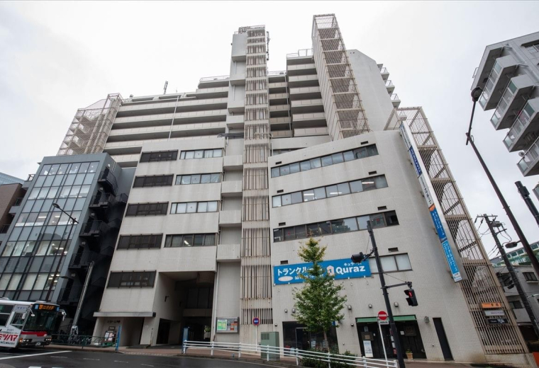 Exterior view of the multi-story Estage Osaki Building featuring a modern white and grey facade.
