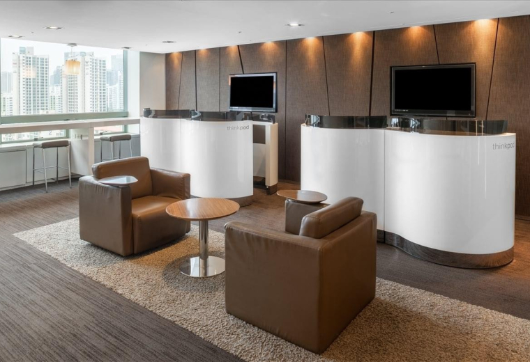 Reception area at Gangnam Building with white curved counters and brown leather armchairs.