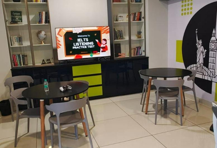 Spacious communal lounge at GRAND BRENTON, 281, Avinashi Road with a ceiling fan, TV, and modern dining tables.