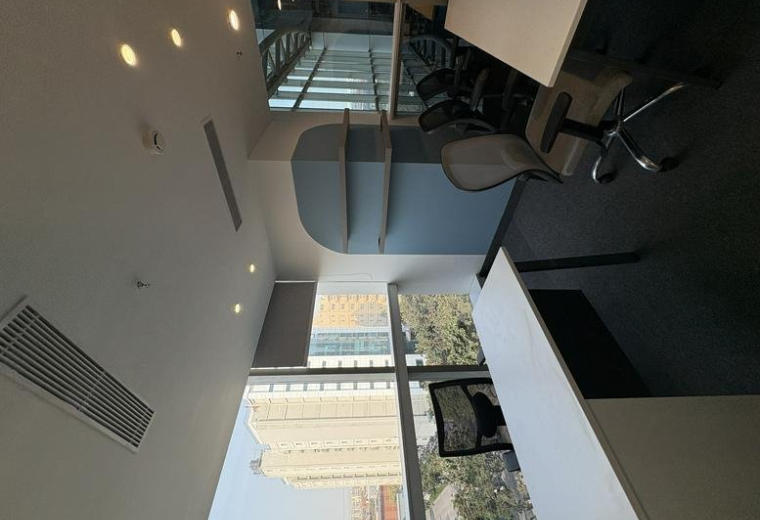Compact private office suite at Ithum Tower A featuring an arched blue accent wall and ergonomic chair.