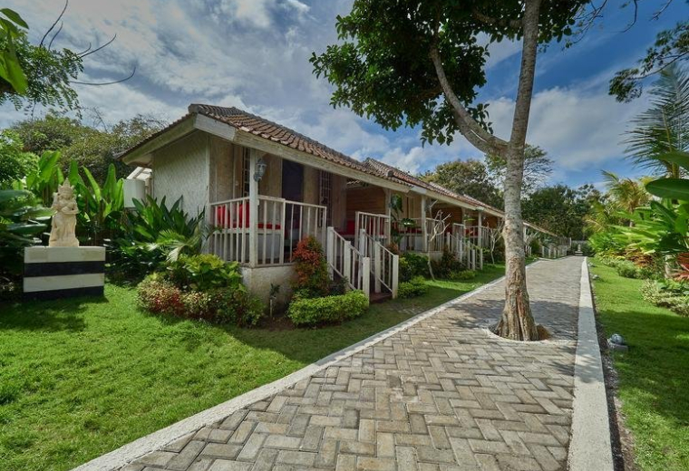 Exterior view of the traditional-style bungalows and stone path at The Tempekan Heritage.