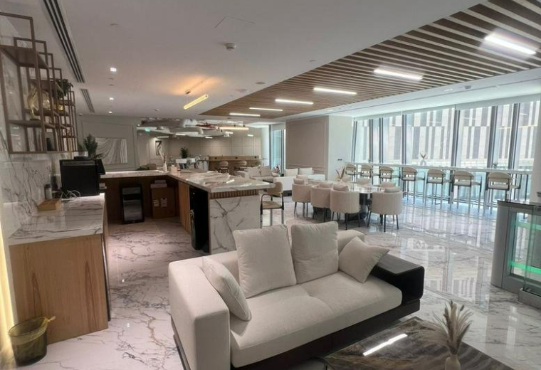 Elegant lounge and dining area with marble floors and contemporary white furniture.