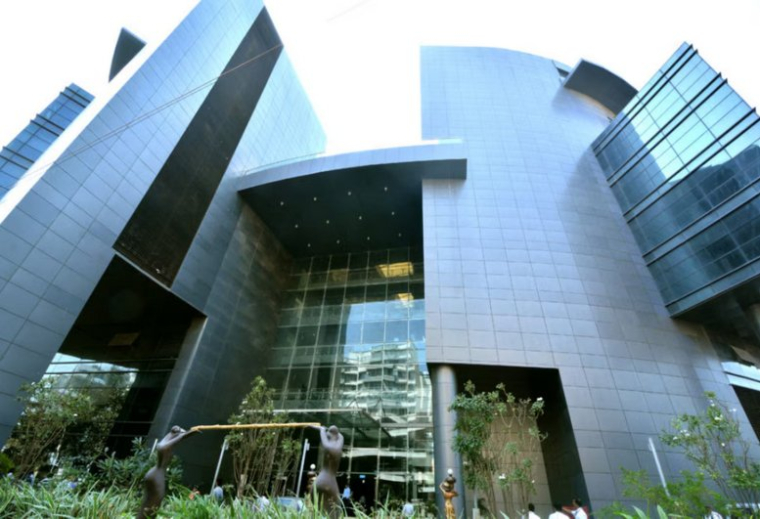 Low-angle view of the modern, geometric glass and stone facade of Kaledonia.