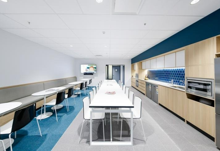 Spacious kitchen and breakout area at Mezzanine Level, Aspley Hypermarket with long communal tables.