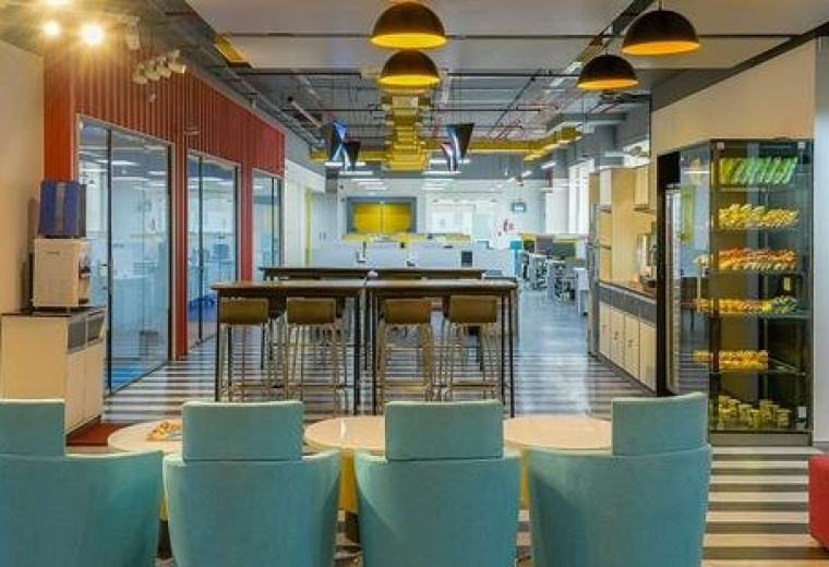 Spacious breakroom at N Heights with geometric pendant lights and a well-equipped kitchen area.