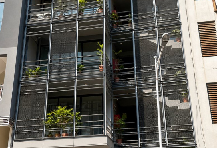 Exterior view of the modern Nasir Arcade building facade with balconies and green plants.