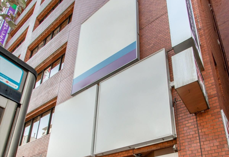 Street view of the brick Nukariya Building 6F facade with white signage panels.