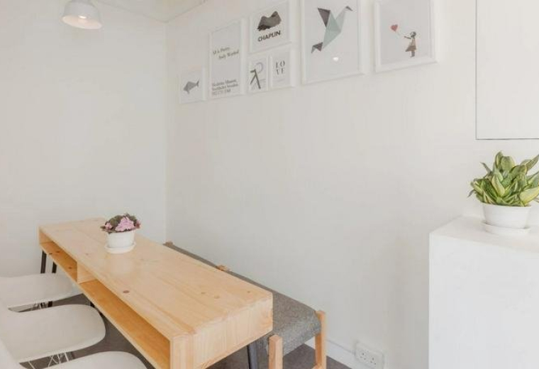 Bright communal dining area at Radio City, 15/F, 505 Hennessy Road with wooden table and framed wall art.